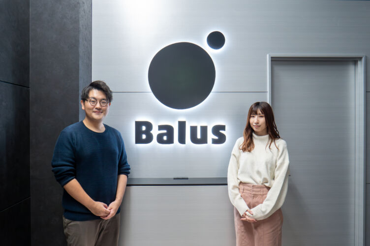 バルス株式会社の伊藤さんと横矢さんが会社のエントランス前に並ぶ様子