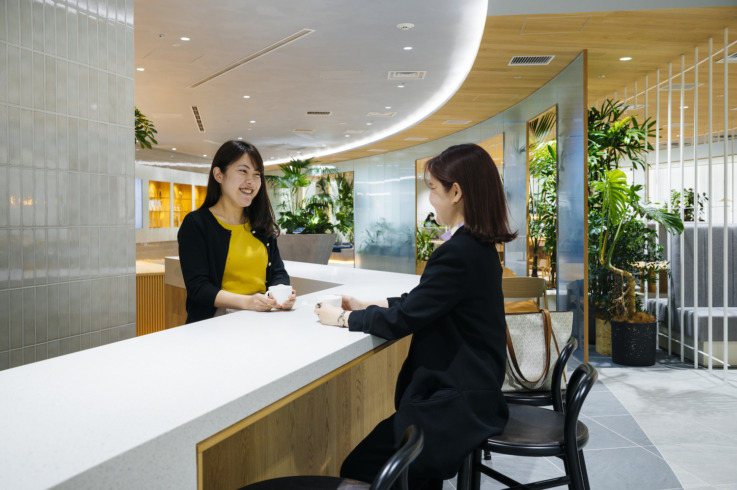 株式会社電通デジタルのオフィス「汐留PORT」でコーヒーを飲む2人の社員