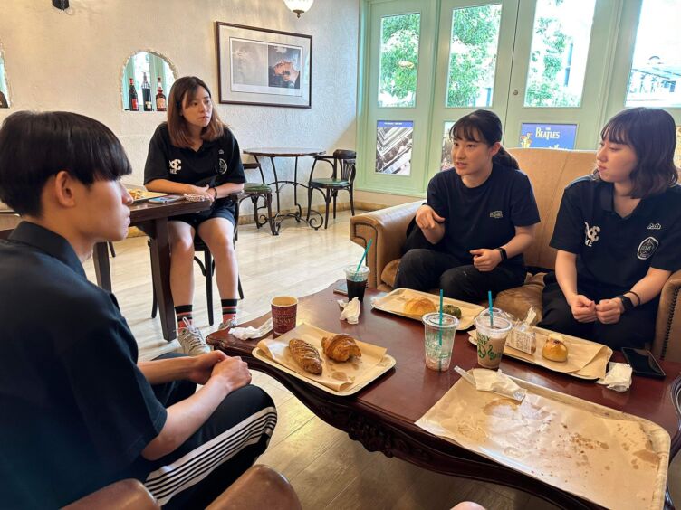 TOKYO DIMEのインターンに参加する学生4人が食事を取りながら会話する様子