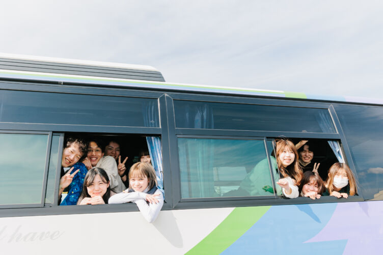 株式会社FOR YOUのメンバーが社員旅行用のバスに乗って記念撮影する様子