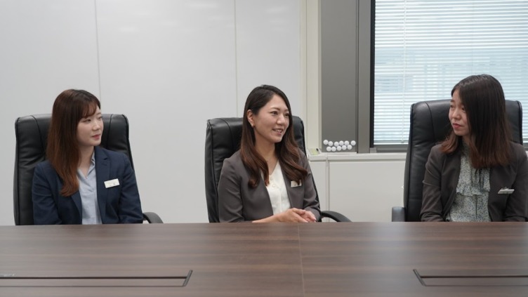 ハウスコム株式会社の女性スタッフ3名が並んで椅子に座っている様子