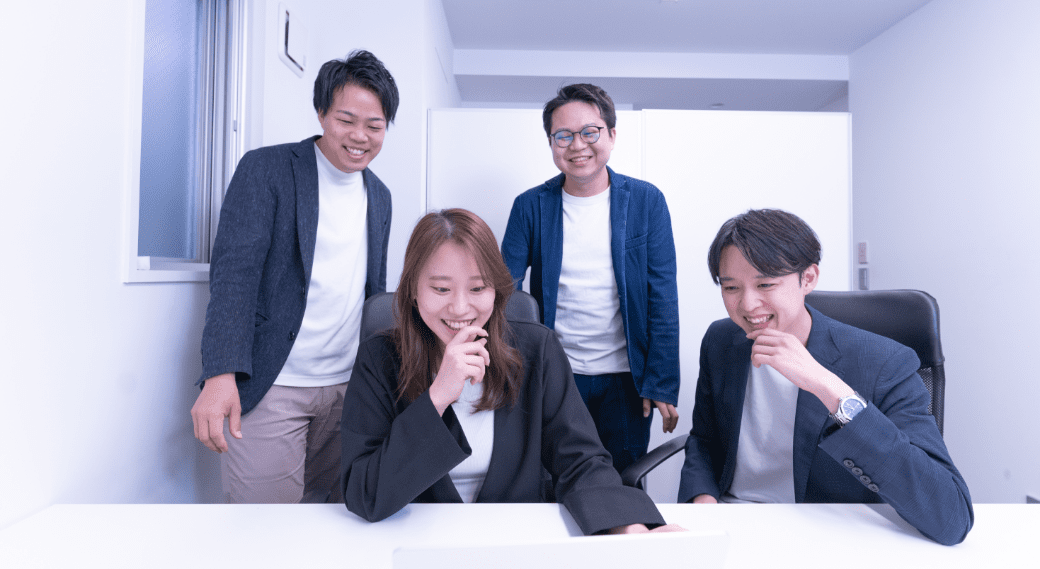 笑顔でパソコンに向かう株式会社Momentum Youthの社員たち