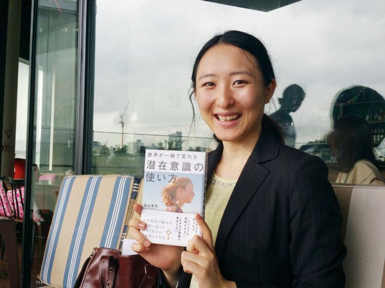 ワンネス株式会社の石山さんが著した書籍を手にする女性