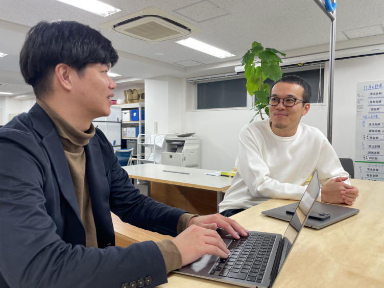 株式会社オースタンス代表の菊川諒人さんと経営企画の田島翔也さんが並んで会話する様子