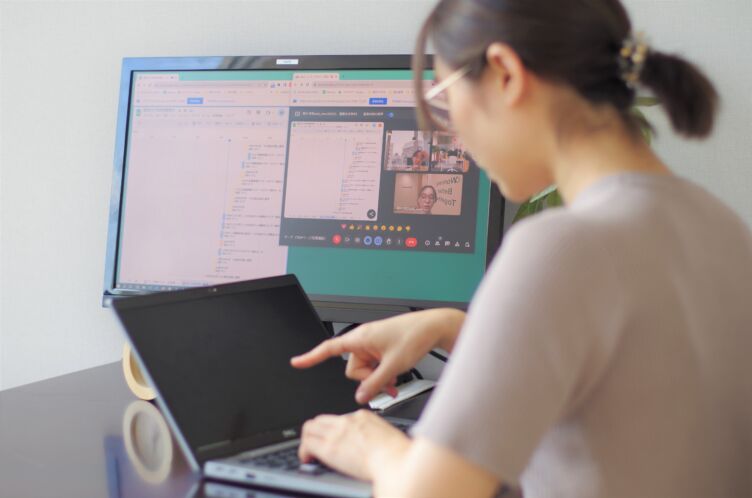 パソコンに向かって仕事をするピースマインド株式会社の女性社員