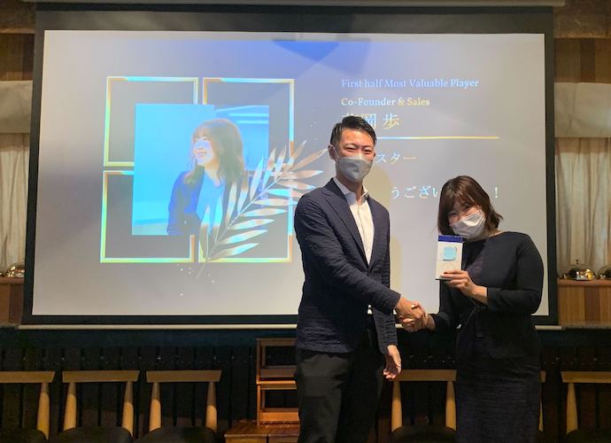 株式会社シュアーイノベーションの花岡さんが社長賞を授与されているようす