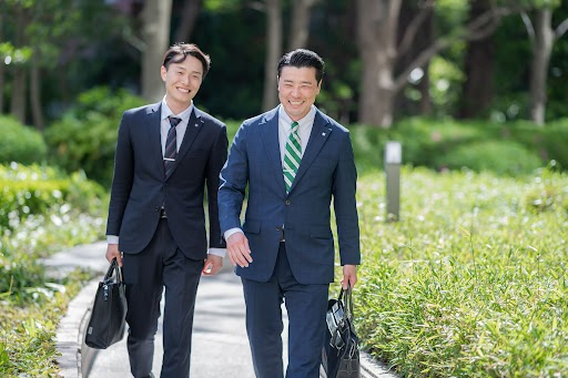 タカマツハウス株式会社の男性社員2名が笑いながら並んで歩いている様子