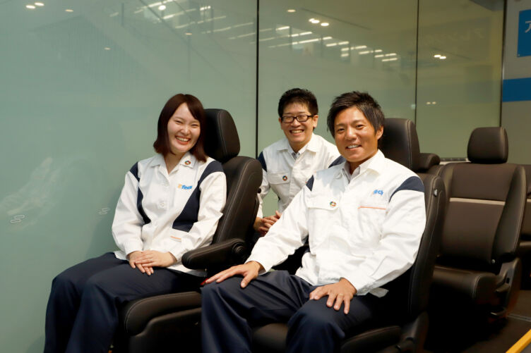 テイ・エス テック株式会社の尾崎さん、木元さん、大森さんが自社製品のシートに座るようす