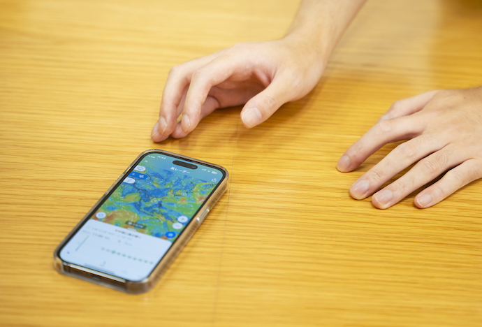 ヤフー株式会社のCTO室アプリ統括部所属エンジニアである田中さんがスマートフォンを操作するようす